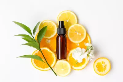 an amber bottle with slices of sweet orange and orange blossom.