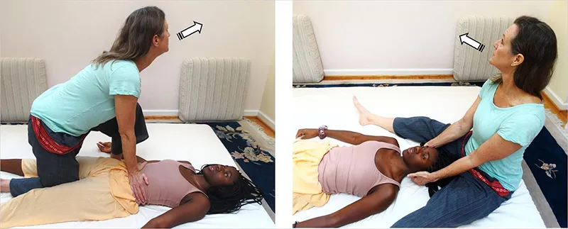 a female massage therapist exhaling away from the client during floor work.