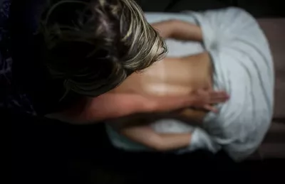 a female MT gives a female client a massage to the back area while apply pressure.