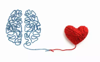 blue threads making the shape of a brain tied together to red threads that form the shape of a heart.