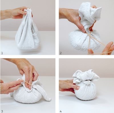 a person's hands preparing and typing a cotton cloth to make an herbal compress.