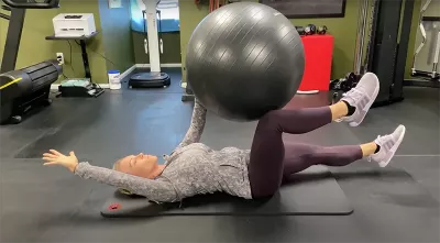 Author Marisa Savino uses a fitness ball for stability during an exercise.