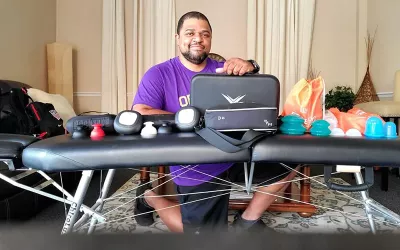 Desmond Diaz poses for a picture from behind his massage table.