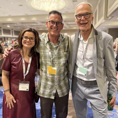 Three people pose for a photo in a conference room at the 7th Fascia Research Congress.
