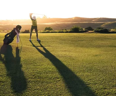 a right-handed golfer taking a swing. 