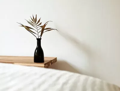 An empty room with space between a wall and decor, and a massage table.