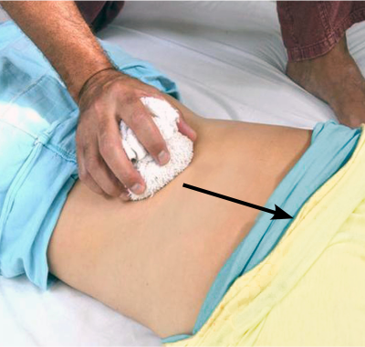 an MT demonstrates pressure sliding with a hot compress up along a client's back.
