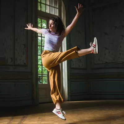 A woman performs contemporary dance technique in a studio.