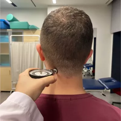 A client has a pain pressure threshold algometer held at their neck.