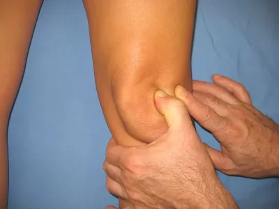 a massage therapist grasps the need to palpate it and move it from side to side.
