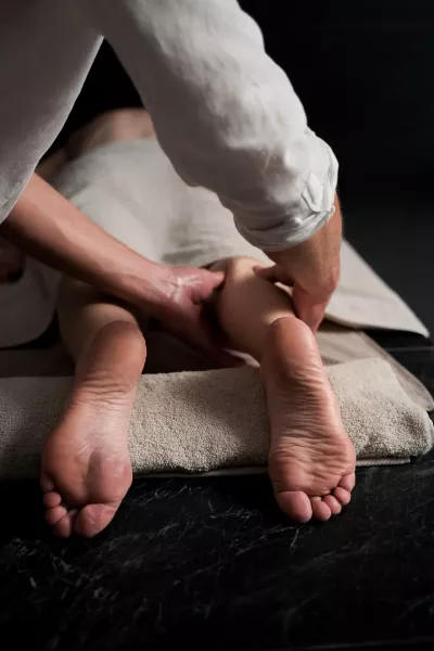 A massage therapist massaging a client's leg.