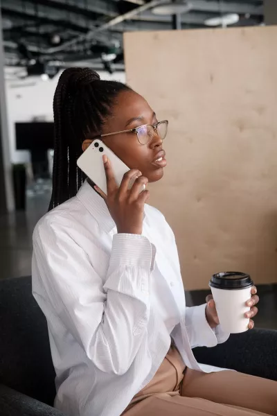 Black woman on cell phone in office setting.