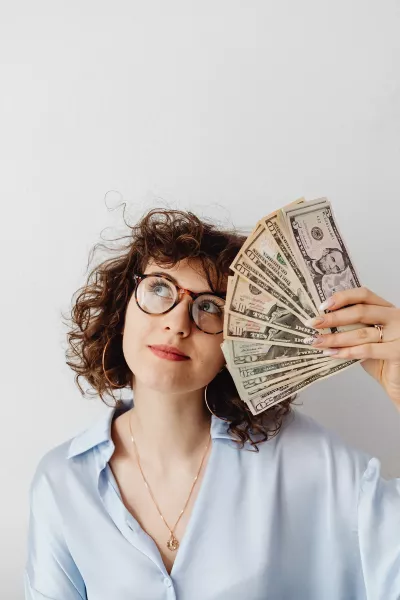 Woman holding handful of cash.