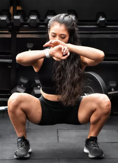 Woman doing squat in gym. 