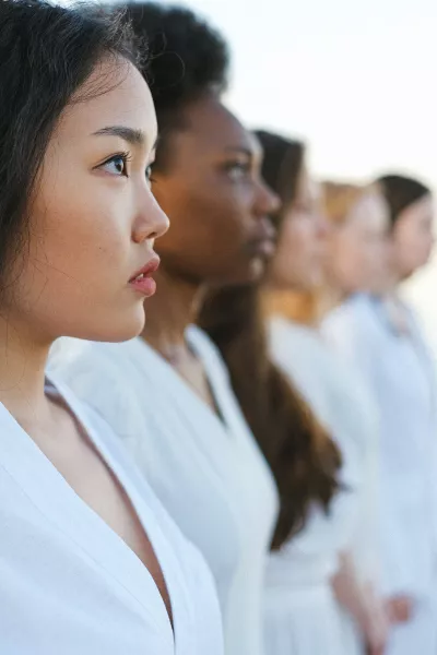 A line of women of all different skin tones.