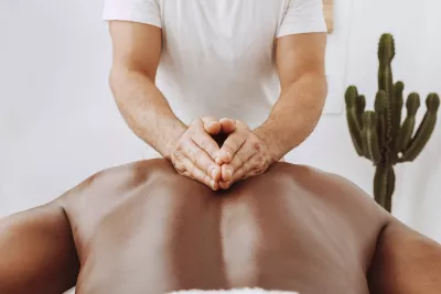 A massage therapist massages a client's back.