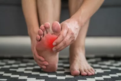 A person massages their own foot.