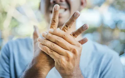 Man holding and massage his right hand with his left hand, in pain.