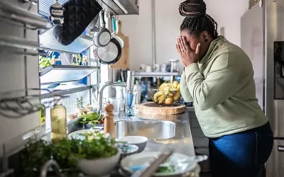 Woman crying in kitchen.