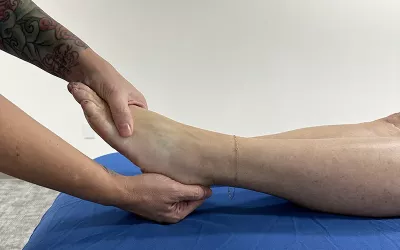 massage therapist demonstrating dorsiflexion on a client.