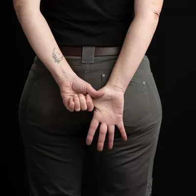 Demonstrating an exercise with hands held behind the back and stretching the thumb.