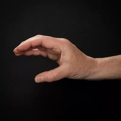 Demonstration of placing the thumb in a “C,” as if you are holding a ball.