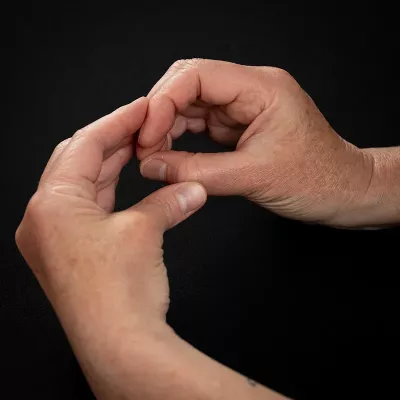 Demonstration of pinching motion exercise with supporting hand.