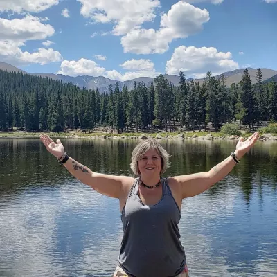 Heather Topoly standing with arms outstretched in the mountains.