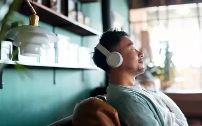 A man sits back and relaxes with his headphones on.