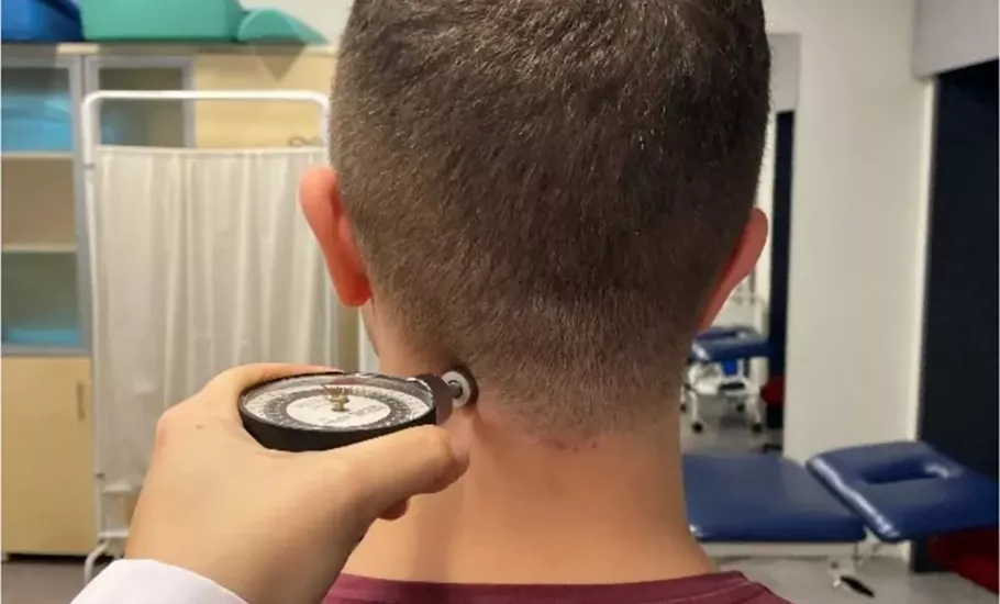 A client has a pain pressure threshold algometer held at their neck.