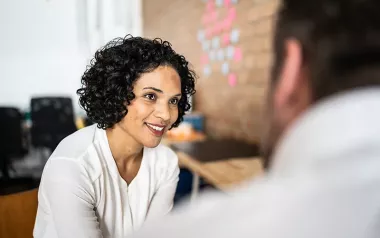 A woman and a man have a discussion in a professional mentor relationship.