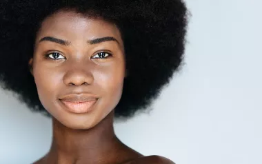 A Black woman smiles at the camera.