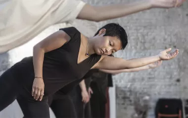 People go through movement exercises, balancing on one leg and extending one arm.