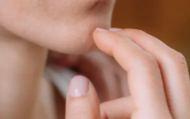 Female tapping her chin with her fingers.