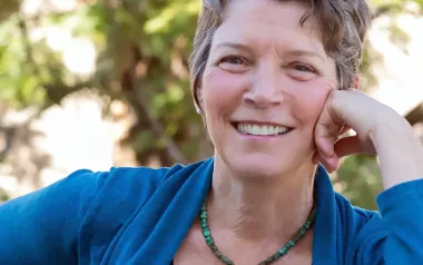 Dr. Betty Martin smiling with her hand to her face.