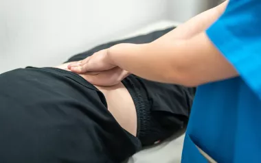 Massage therapist applying massage to client on massage table.