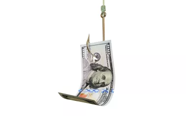 A $100 bill speared on a large fishhook.