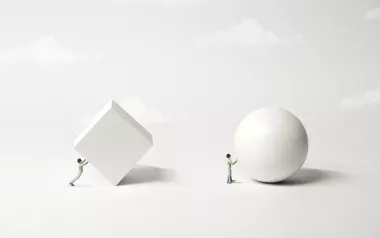 A figure trying to roll a white 3D block, and a second figure rolling a white sphere.