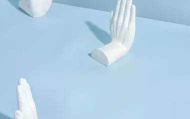 Three sculptures of hands putting their hands up.