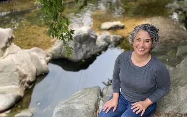  A professional portrait of Kerry Jordan sitting by a creek.