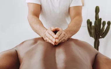 A massage therapist massages a client's back.
