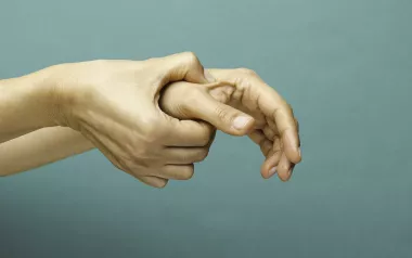 Self-massage of right hand on the left hand's thumb. 