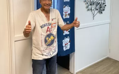 Jonathan Twidwell gives two thumbs up to the camera while standing in his studio.