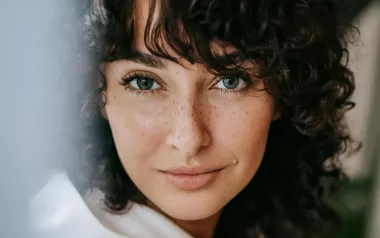 close up of a woman with brown hair looking at the camera.