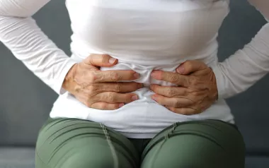 A woman clutches her stomach.