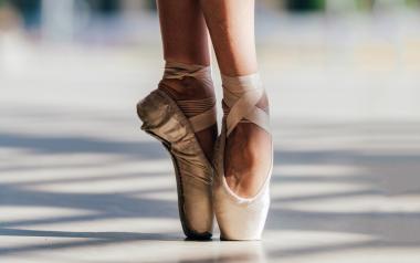 A pair of feet on tip toe in pointe shoes.