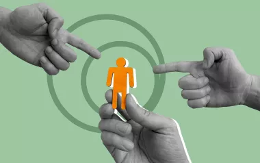 One hand holds up a cutout of a person, while two other hands point at the figure.