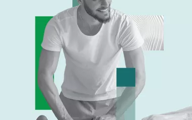 A massage therapist works on a prone client's lower leg.