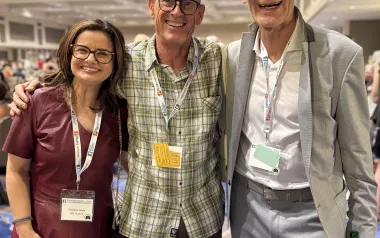 Three people pose for a photo in a conference room at the 7th Fascia Research Congress.