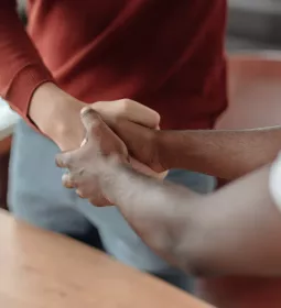 Two people shake hands, one of them using two hands.